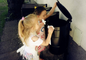 Dziewczynki wyrzucają chusteczki do pojemnika na odpady mieszane